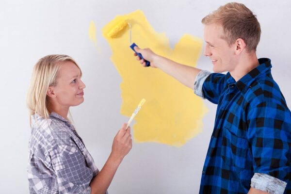 Couple painting wall together